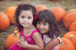 sisters in a pumpkin patch