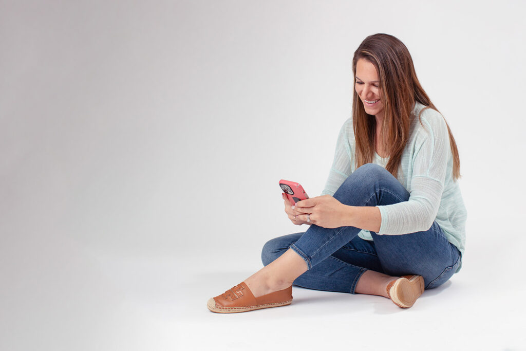 woman sitting and looking at her phone in branding photos