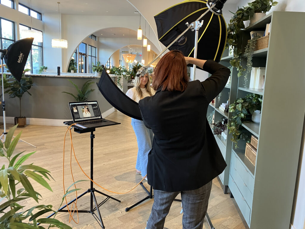 headshot setup on-location shot from behind photographer's should to see client on the other side with lighting setup in an indoor location