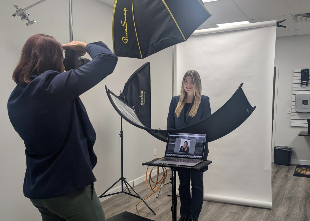 the back of the photographer taking a photo of a staff member with mobile headshot studio setup